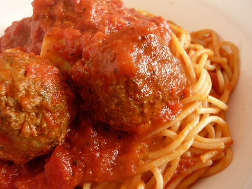 Close on plate of spaghetti with three meatballs and red sauce