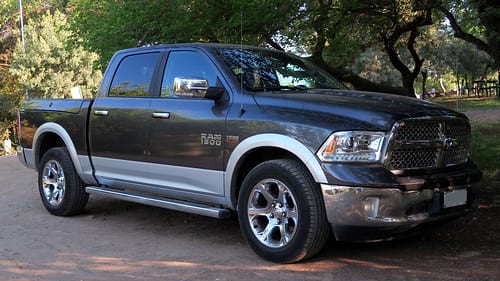 Used black RAM 1500 parked on street under trees